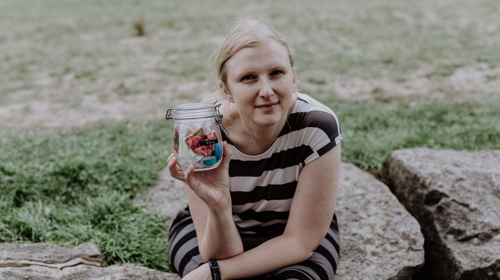 Amelie hält ein Glas mit Müll