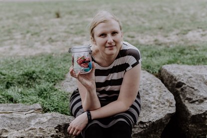 Amelie hält ein Glas mit Müll