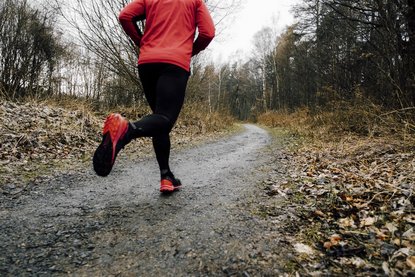 Person joggt auf einem Waldweg