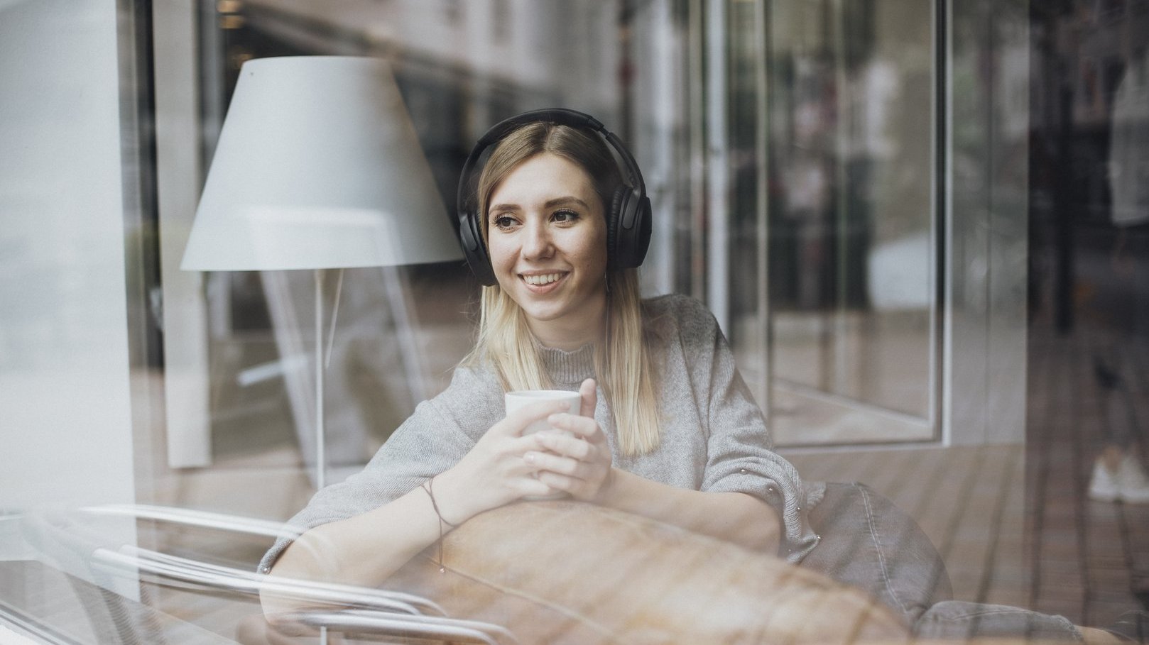 Junge Frau mit Kopfhörern hört einen Podcast 